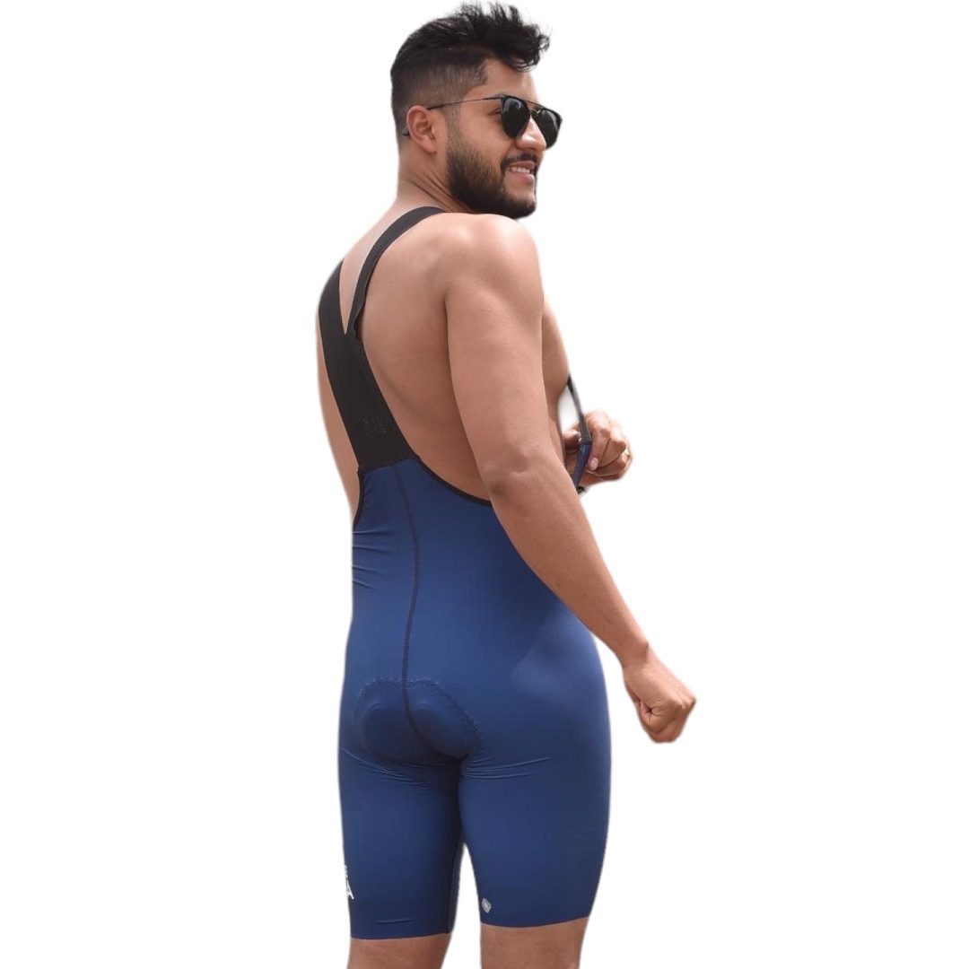 Modelo de espalda mostrando los tirantes elásticos de la licra de ciclismo azul oscuro