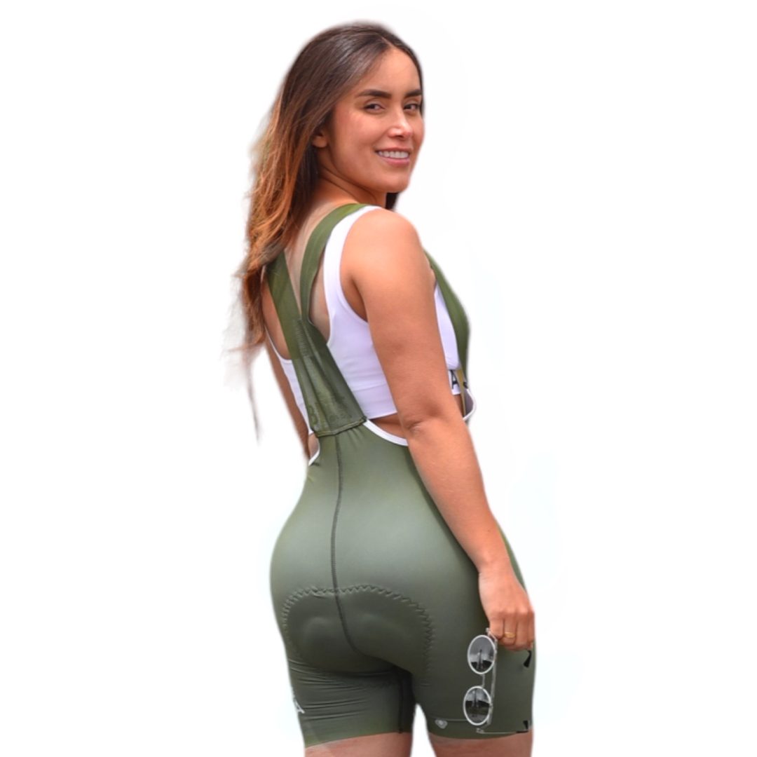 Modelo de espalda mostrando los tirantes con borde blanco de la licra de ciclismo verde