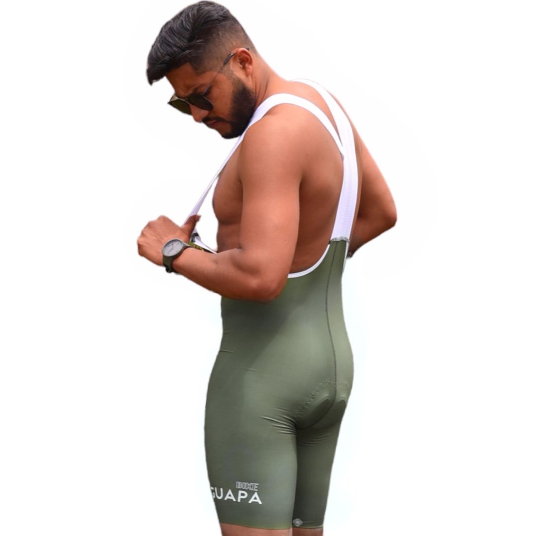 Modelo de perfil mostrando el ajuste y tiras blancas de la licra de ciclismo verde para hombre