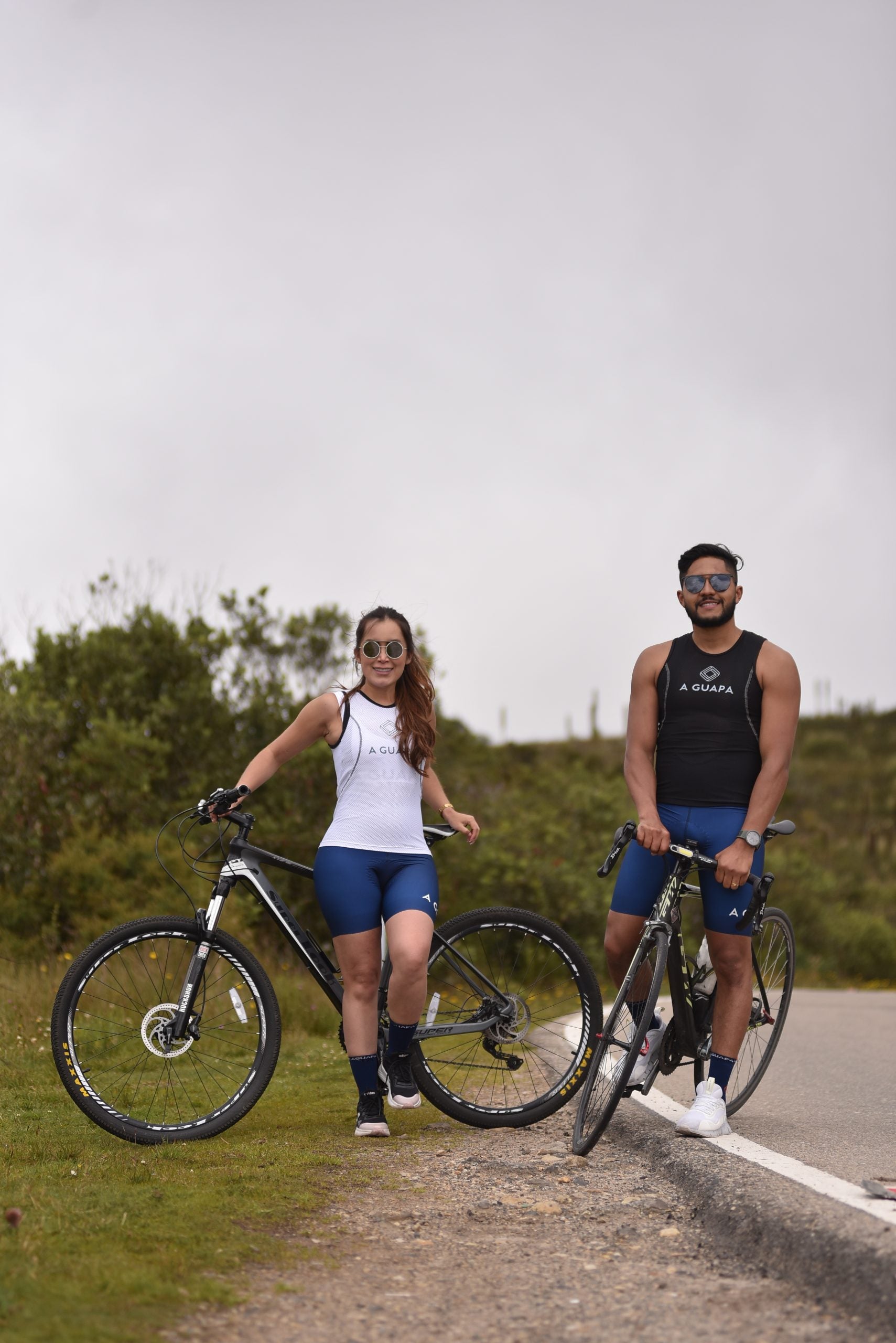 Pareja de ciclistas en carretera con su ropa de ciclismo para hombre y mujer de A Guapa Bike